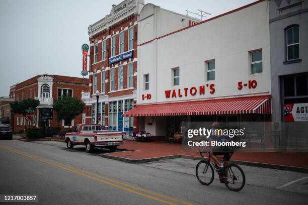 Person rides a bicycle past the Walmart Museum's Walton's 5 & 10 in Bentonville, Arkansas, U.S., on Thursday, May 28, 2020. The annual Walmart Inc....