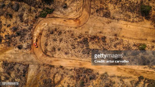 dramatic landscape and car from above, dirt roads - autorallye stock-fotos und bilder