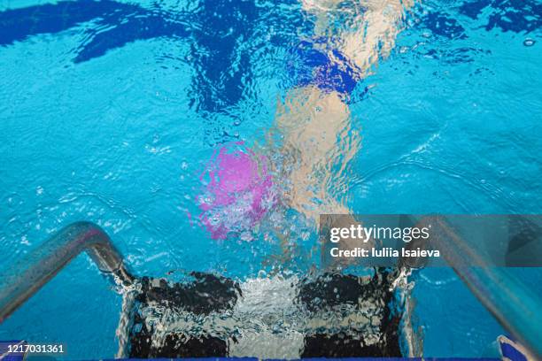 unrecognizable boy swimming in pool - hallenbad leer stock-fotos und bilder