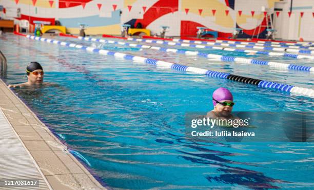 happy small kid swimming with father in pool - kids swim caps stock pictures, royalty-free photos & images