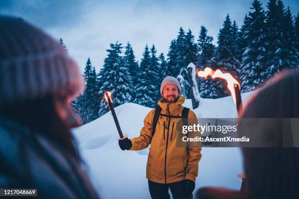 vrienden wandelen door sneeuw bij schemering - fakkel stockfoto's en -beelden