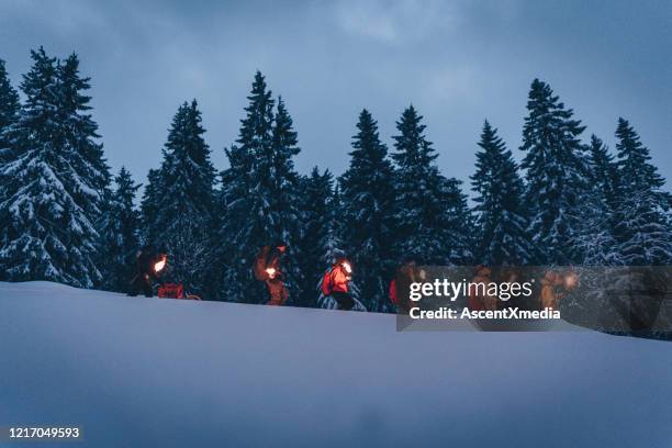 freunde wandern in der schlange durch schnee - fackel stock-fotos und bilder