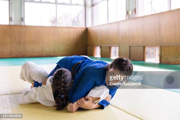 young female athletes playing judo in dojo - black belt martial arts stock pictures, royalty-free photos & images