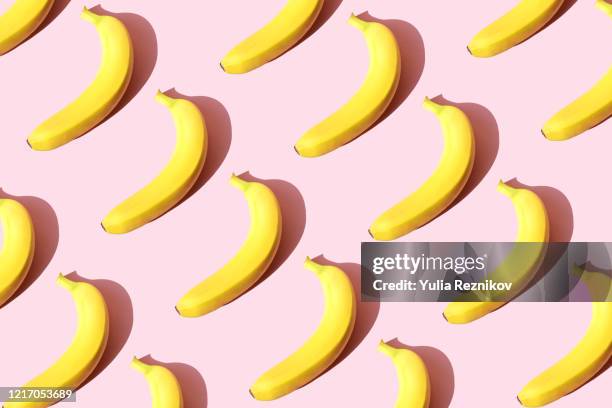 repeated banana on the pink background - coloured light patterns in a studio environment stock pictures, royalty-free photos & images