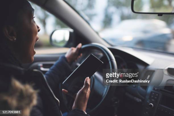 chockad förare kvinna rullning, med hjälp av en smartphone när du kör en bil strax före en olycka. - panic bildbanksfoton och bilder