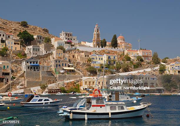 greek fishing boats in protected harbor - symi stock pictures, royalty-free photos & images