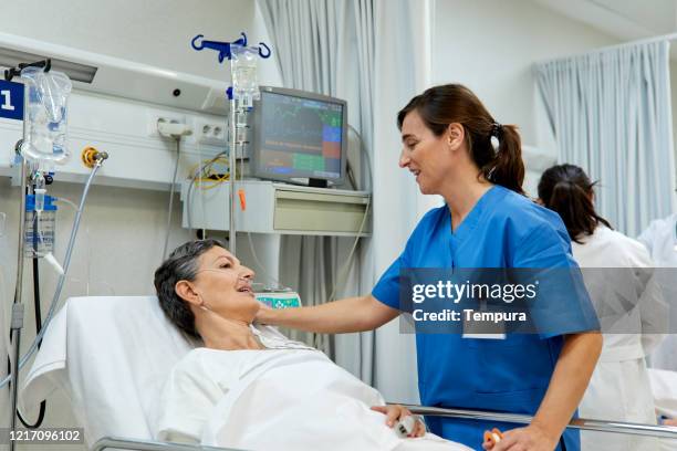 a nurse is talking with a patient lying down o a gurney. - patient lying down stock pictures, royalty-free photos & images