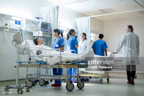 a doctor making rounds and visiting patients at the post operative area. - post operation stock pictures, royalty-free photos & images