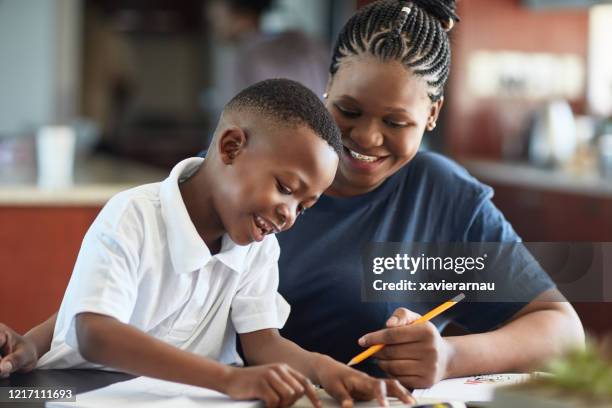 african mother and young son spending creative time together - african cornrow braids stock pictures, royalty-free photos & images