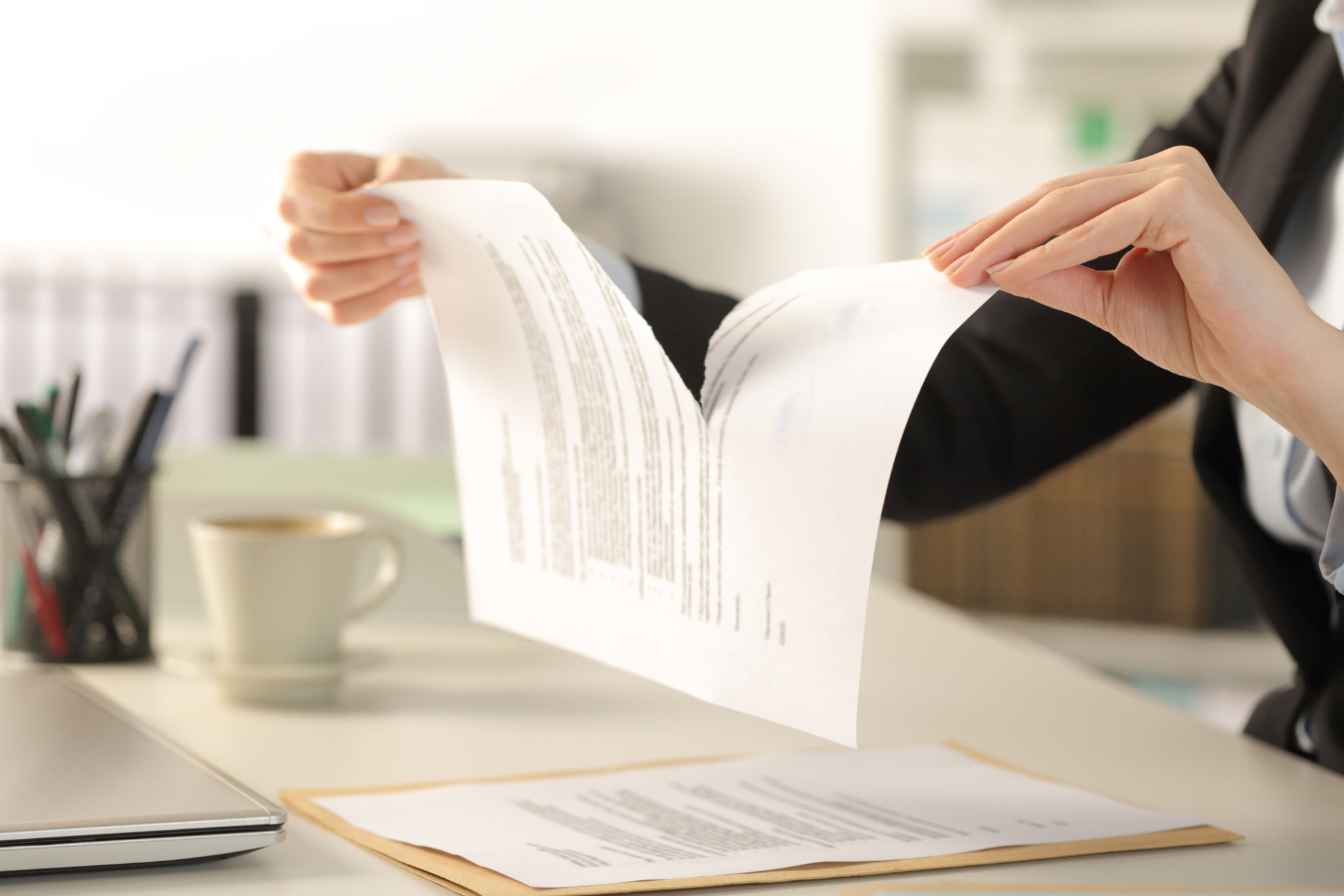 Business woman hands breaking document at the office Business woman hands breaking document at the office