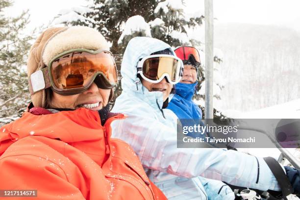 a community of seniors riding the ski lift - woman on ski lift stock pictures, royalty-free photos & images