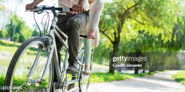 coppia in bicicletta in tandem nel parco - tandem bicycle foto e immagini stock