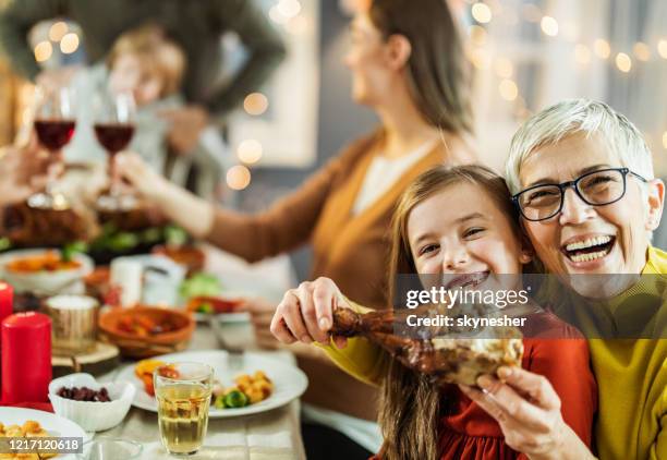 happy grandmother and granddaughter having fun with turkey leg at home. - turkey leg stock pictures, royalty-free photos & images