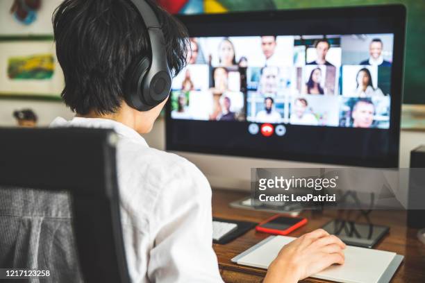 woman working at home having a video conference with colleagues - zoom event stock pictures, royalty-free photos & images