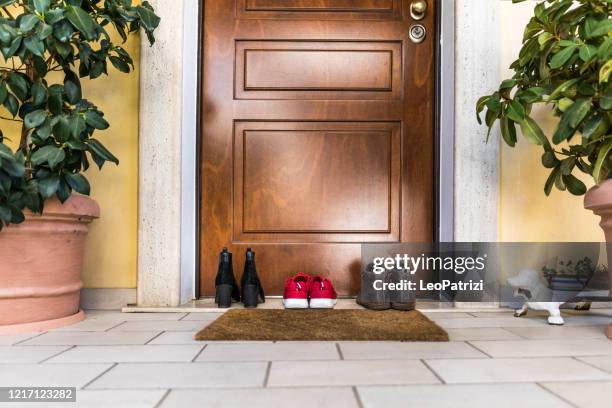 family shoes on the porch by the doorstep - house doorway stock pictures, royalty-free photos & images