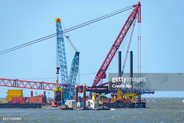 large construction crane on a barge on a off shore wind turbine construction site - offshore wind turbine installation stock pictures, royalty-free photos & images