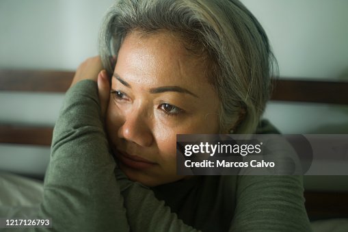 Mature lady crisis - attractive middle aged woman with grey hair sad and depressed in bed feeling scared and lonely thinking worried about covid-19 virus pandemic during home lockdown Mature lady crisis - attractive middle aged woman with grey hair sad and depressed in bed feeling scared and lonely thinking worried about covid-19 virus pandemic during home lockdown