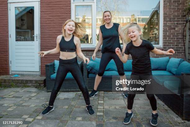 a beautiful mother and young daughters working out at home during the lockdown - family lockdown stock pictures, royalty-free photos & images