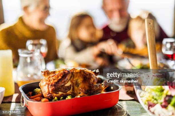 fermez-vous vers le haut de la viande de poulet rôtie pendant le déjeuner de famille. - poulet roti photos et images de collection