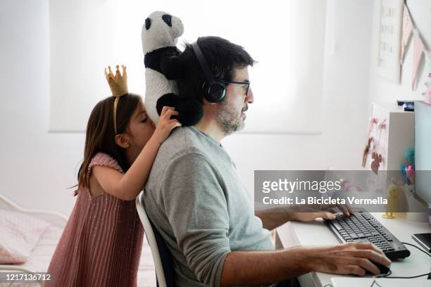 man doing telework and a little girl playing around - lavoro a domicilio foto e immagini stock