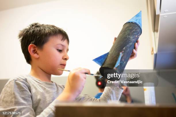 elementary age school boy making space rocket - model rocket stock pictures, royalty-free photos & images