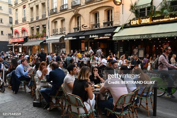 People eat and have drinks on restaurant and cafe terraces in the rue de Buci in Paris on June 2 as cafes and restaurants reopen in France with the...