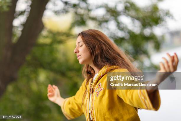 a woman meditating in nature - chanting stock pictures, royalty-free photos & images