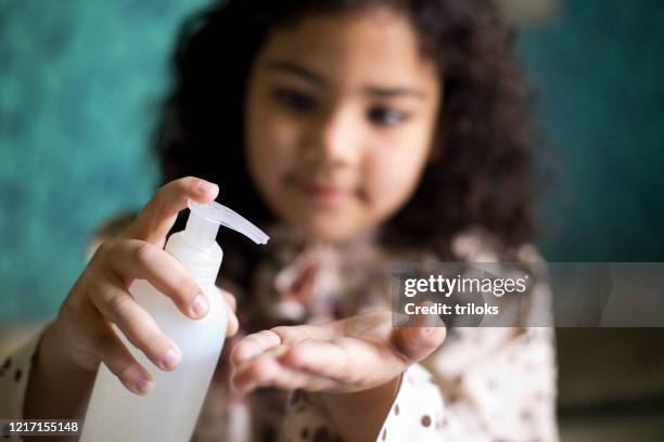 girl pouring sanitizer on palm of hand - child palm of hand stock pictures, royalty-free photos & images