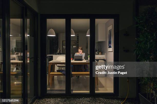 woman working from home at night - kitchen window woman stock pictures, royalty-free photos & images