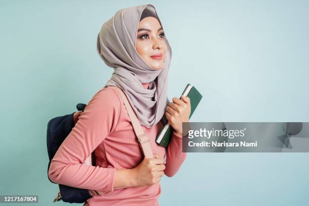 confident asian muslim student girl holding book , library, university, learning and education concept. - beautiful college girls stock pictures, royalty-free photos & images