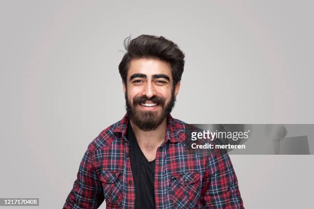 portrait of smiling handsome man looking at camera over isolated gray background - west asia stock pictures, royalty-free photos & images