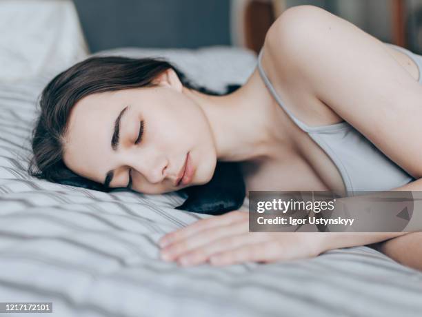 close-up of young woman sleeping on silk pillow - silk pillow stock-fotos und bilder