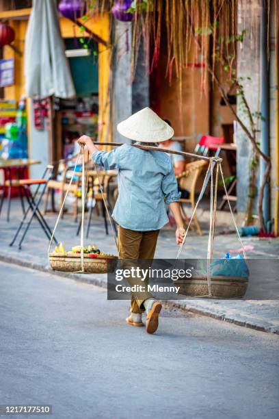 vietnamese woman walking with street food hoi an vietnam - vietnamese street food stock pictures, royalty-free photos & images
