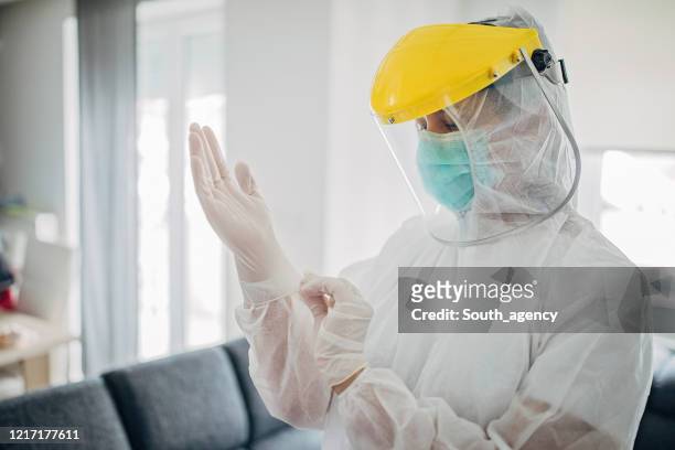 female doctor in full protective suit in home inspection - protective workwear stock pictures, royalty-free photos & images
