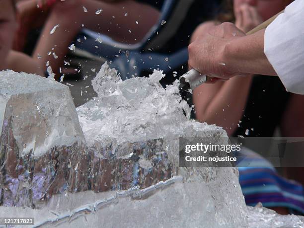 ice sculptor chiseling a creation from a block of ice - carving ice sculpture stock pictures, royalty-free photos & images