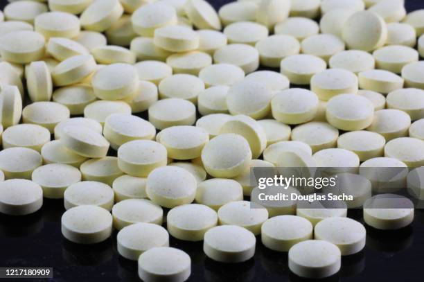 multiple tablet medication on black background - opioids stock-fotos und bilder