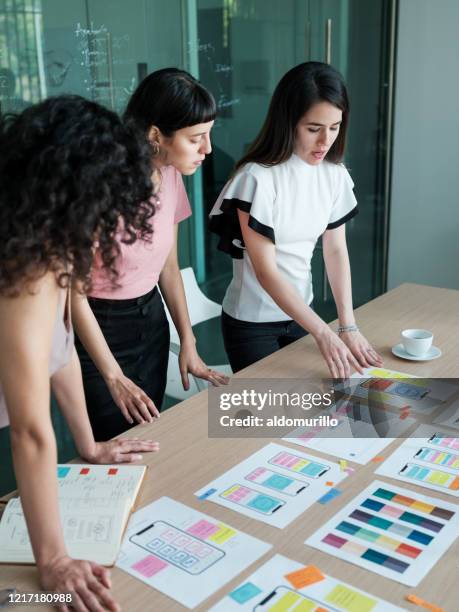 young businesswomen having meeting and looking at documents - user experience stock pictures, royalty-free photos & images