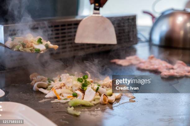 chef cooking mixed vegetable and seafood in japanese teppanyaki restaurant - teppanyaki stock pictures, royalty-free photos & images