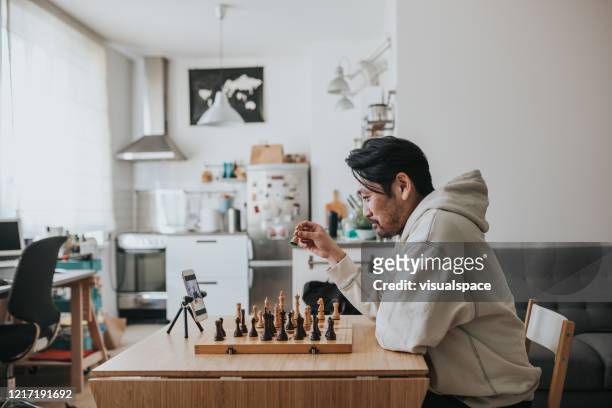 Japanese man playing virtual chess with friend online during social distancing times