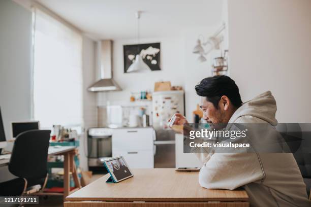 Japanese man drinking whiskey with friends in online meeting during social distancing times
