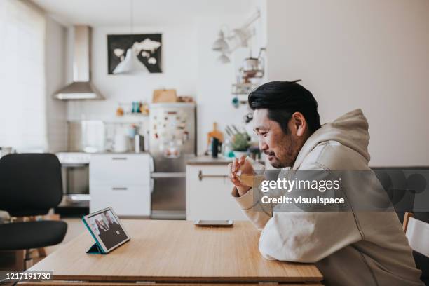 japanese man drinking whiskey with friends in online meeting during social distancing times - drinking alcohol at home stock pictures, royalty-free photos & images