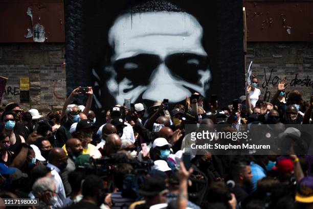 Painting of George Floyd stands behind a group of people gathered at a memorial on the block where he was killed by police on June 2, 2020 in...