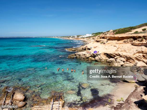 rocky coast at cala migjorn, against clear blue sky in formentera island, spain. - formentera fotografías e imágenes de stock