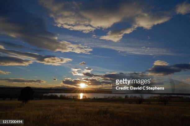 sunstar, sunset over rocky mountains and cherry creek reservoir - aurora colorado stock-fotos und bilder