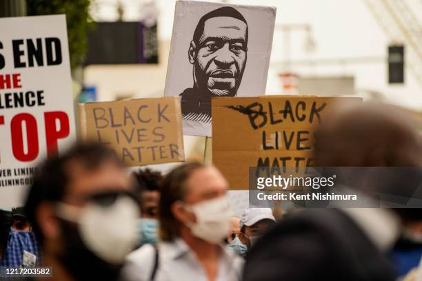 Sign with the likeness of George Floyd is seen as Protesters and Clergy members from the Los Angeles area participate in a march and peaceful protest...