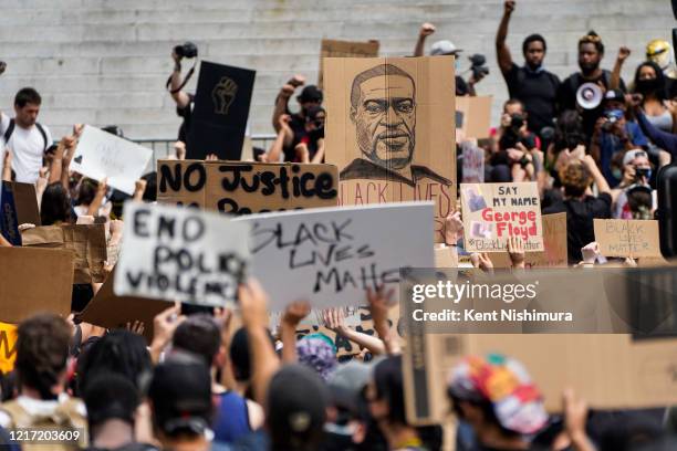 Drawing of the late George Floyd is seen being held as demonstrators chant in front of LA City Hall in downtown Los Angeles on Tuesday, June 2, 2020...