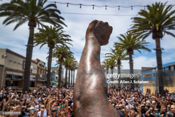 Several hundred Black Lives Matter protesters take a knee and hold their fists in the air during a moment of silence to honor George Floyd during a...