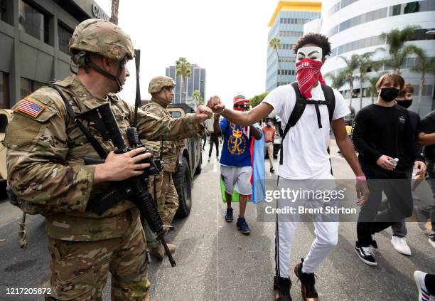 Demonstrator fist bumps a member of the National Guard during a march in response to George Floyd's death on June 2, 2020 in Los Angeles, California....