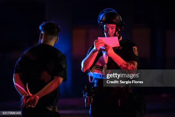 Police officers begin the intake process after a group of protesters were caught and arrested after escaping a caged in area on June 2, 2020 in...