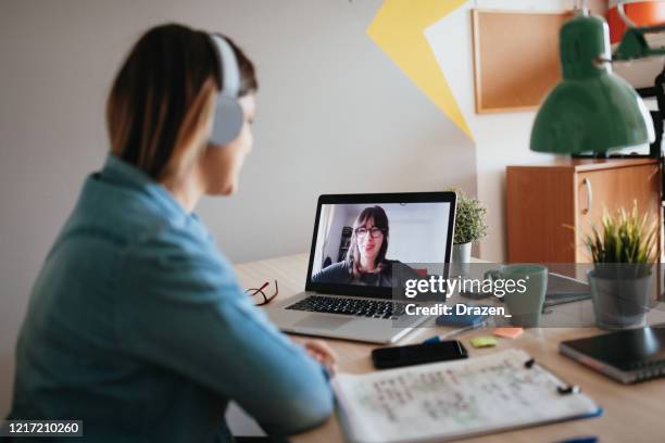 young woman teleconferencing with sister on laptop on conference call - two people video conferencing stock pictures, royalty-free photos & images